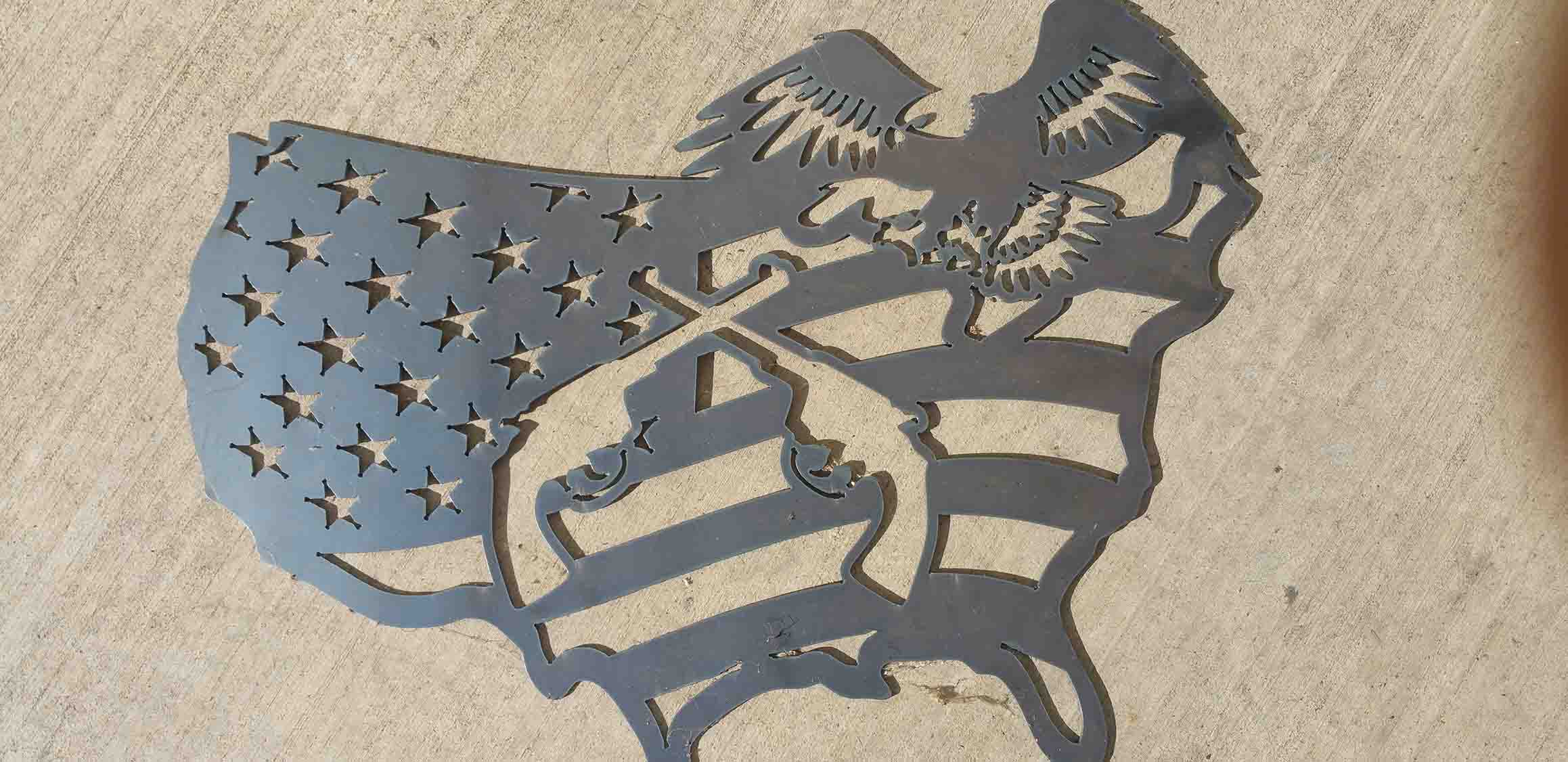 Decoration cutout of flag shaped like the US, with guns and an eagle.
