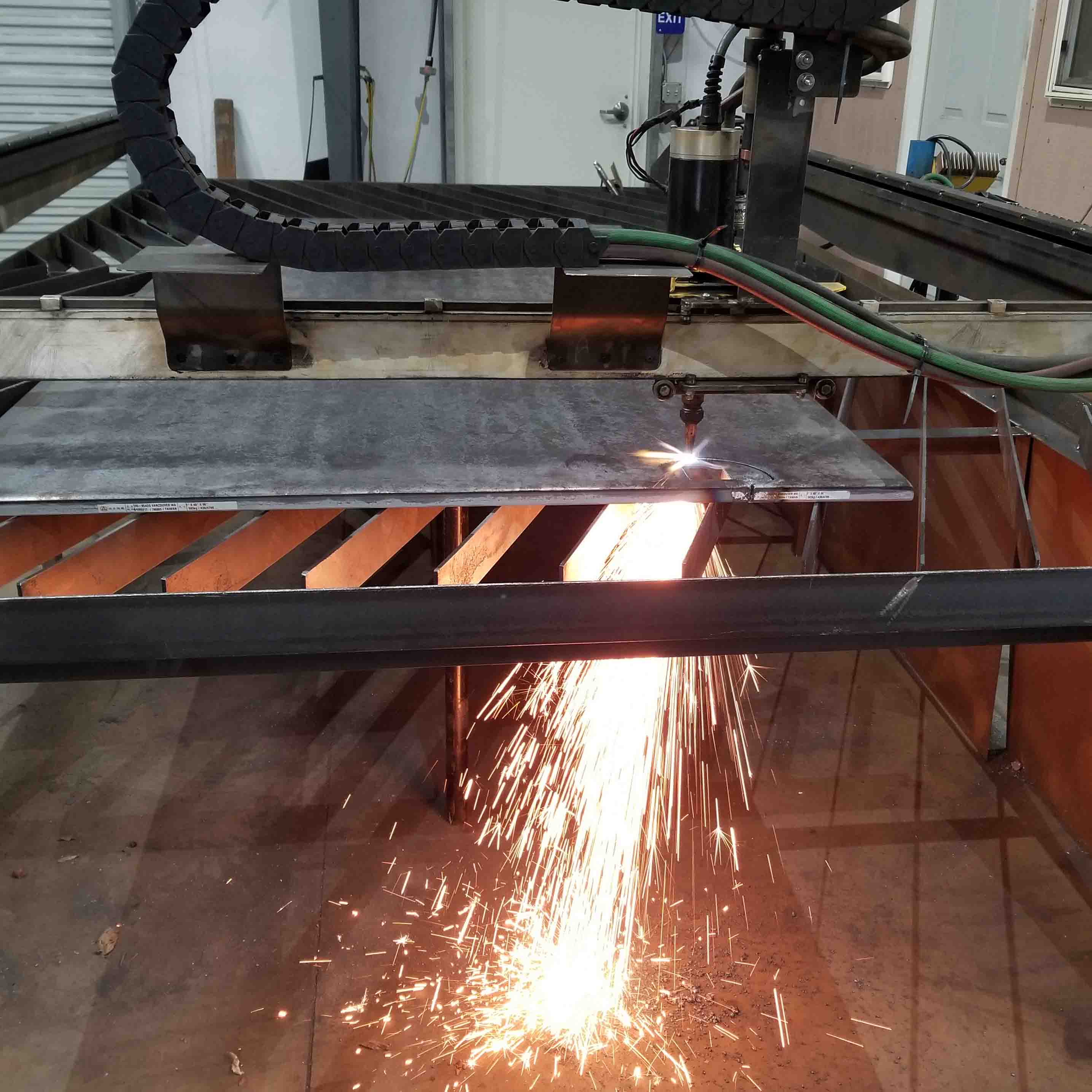 Picture of a CNC plasma table, with torch running.